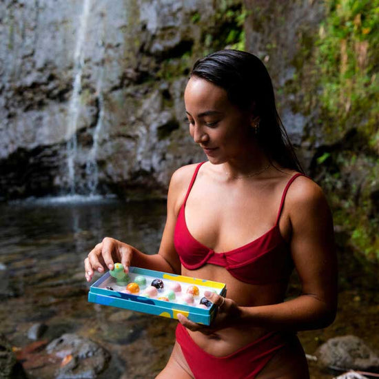 Person in bathing suit holding a KOHO Bon Bon assortment